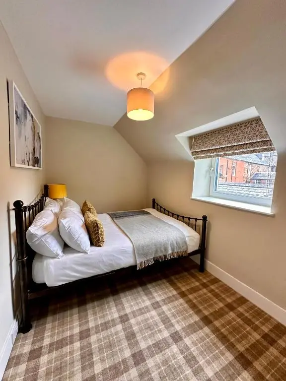 a bedroom with a bed and a window at Warm and Cosy City Centre House in Inverness