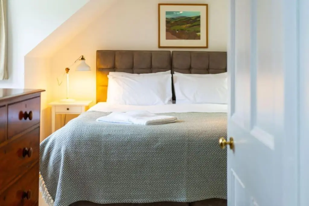 a bedroom with a bed with two towels on it at Westerpark Cottage, Pet & Family Friendly Countryside Retreat, Aberdeenshire in Huntly