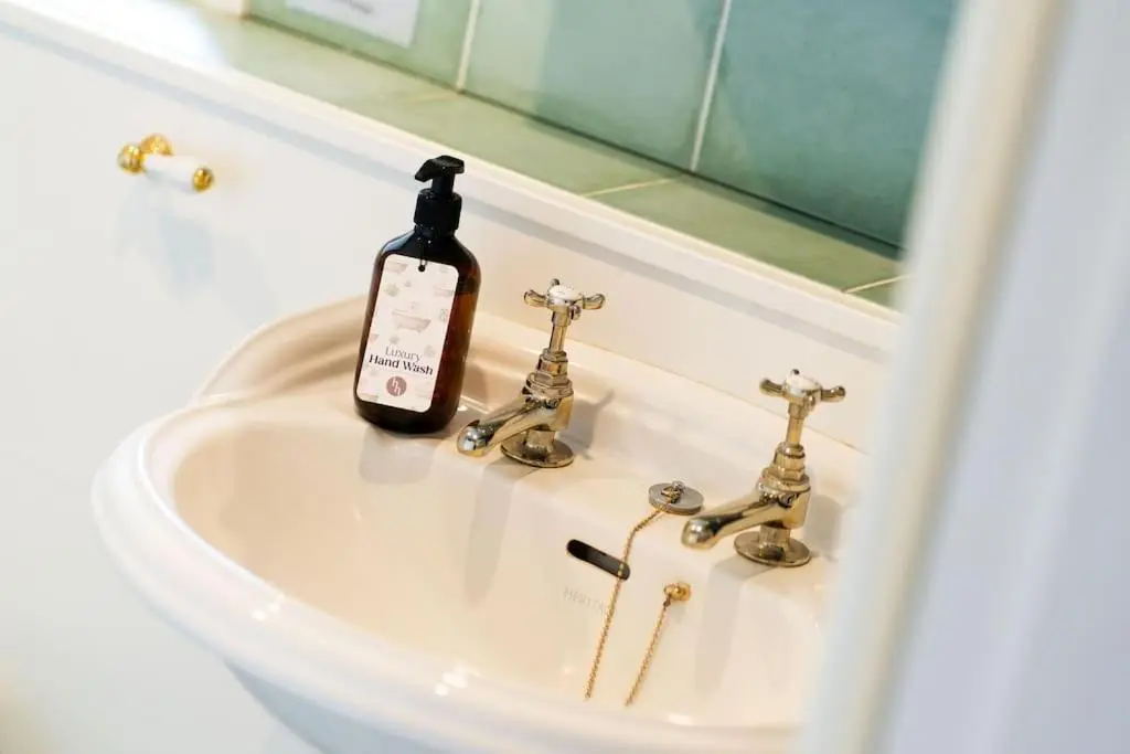 a bottle of wine sitting on top of a sink at Westerpark Cottage, Pet & Family Friendly Countryside Retreat, Aberdeenshire in Huntly