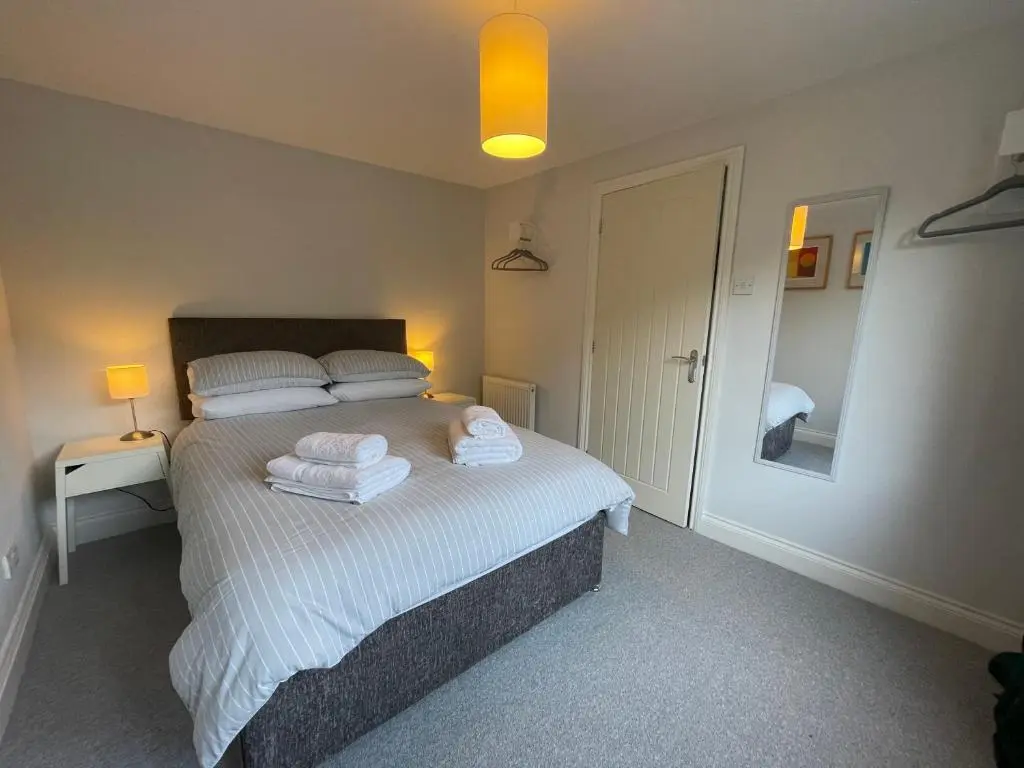 a bedroom with a bed with towels on it at Modern Coastal Retreat, 5-Bedroom, 4-Bathroom Home, with Parking in Portsoy in Portsoy