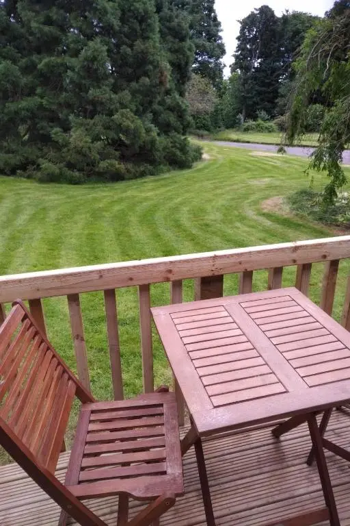 a wooden table and two chairs on a deck at The Bungalow - Ardullie Lodge in Dingwall