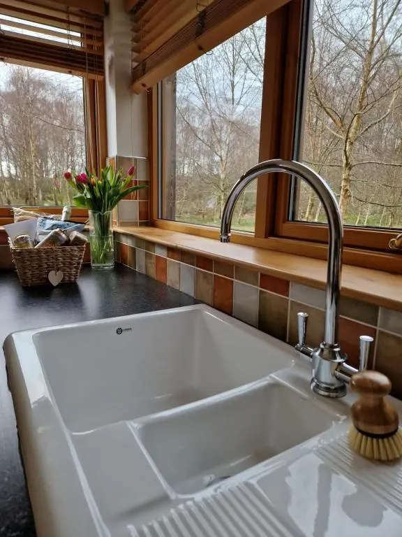 a white sink in a kitchen with a window at Lodges at the Mains in Inverness