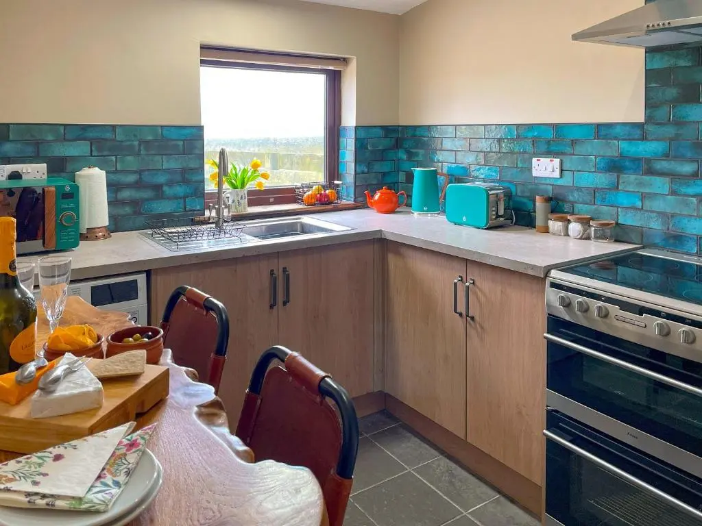 a kitchen with a sink and a table with a table sidx sidx at The Wee Belter in Dornoch