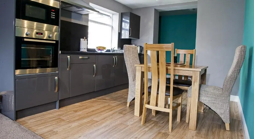 a kitchen with a table and chairs in a kitchen at Riverside Apartments in Wick