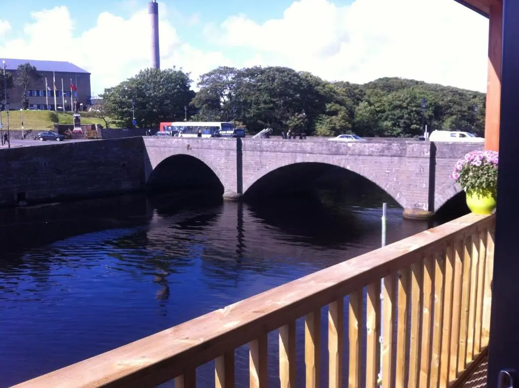 a bridge over a river next to a bridge at Riverside Apartments in Wick