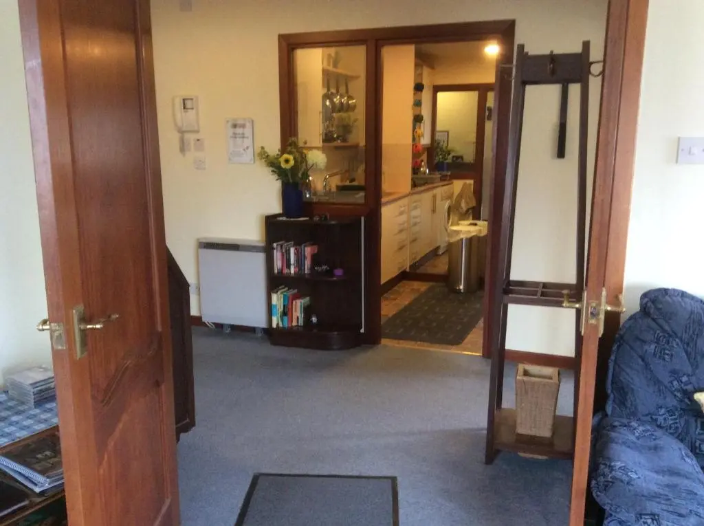 a living room with a door open to a room at Connel Court Apartments in Inverness