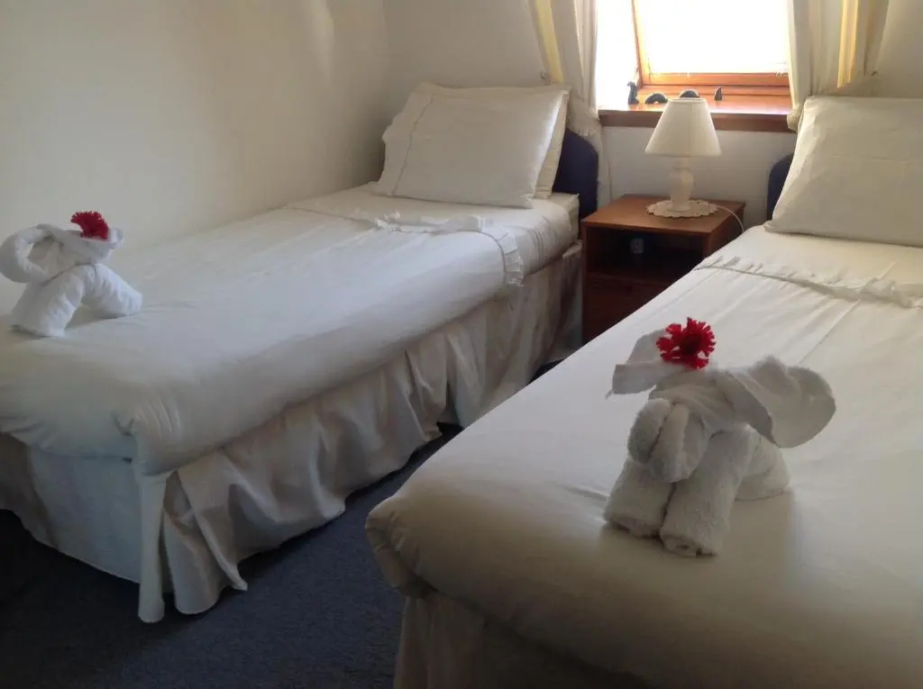 two beds in a hotel room with stuffed animals on them at Connel Court Apartments in Inverness