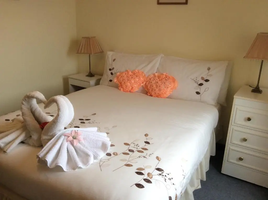 a bedroom with a bed with two swans on it at Connel Court Apartments in Inverness
