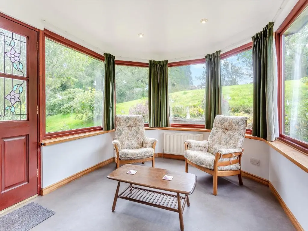 a living room with two chairs and a table and windows at Drummond House Uk42979 in Brackley