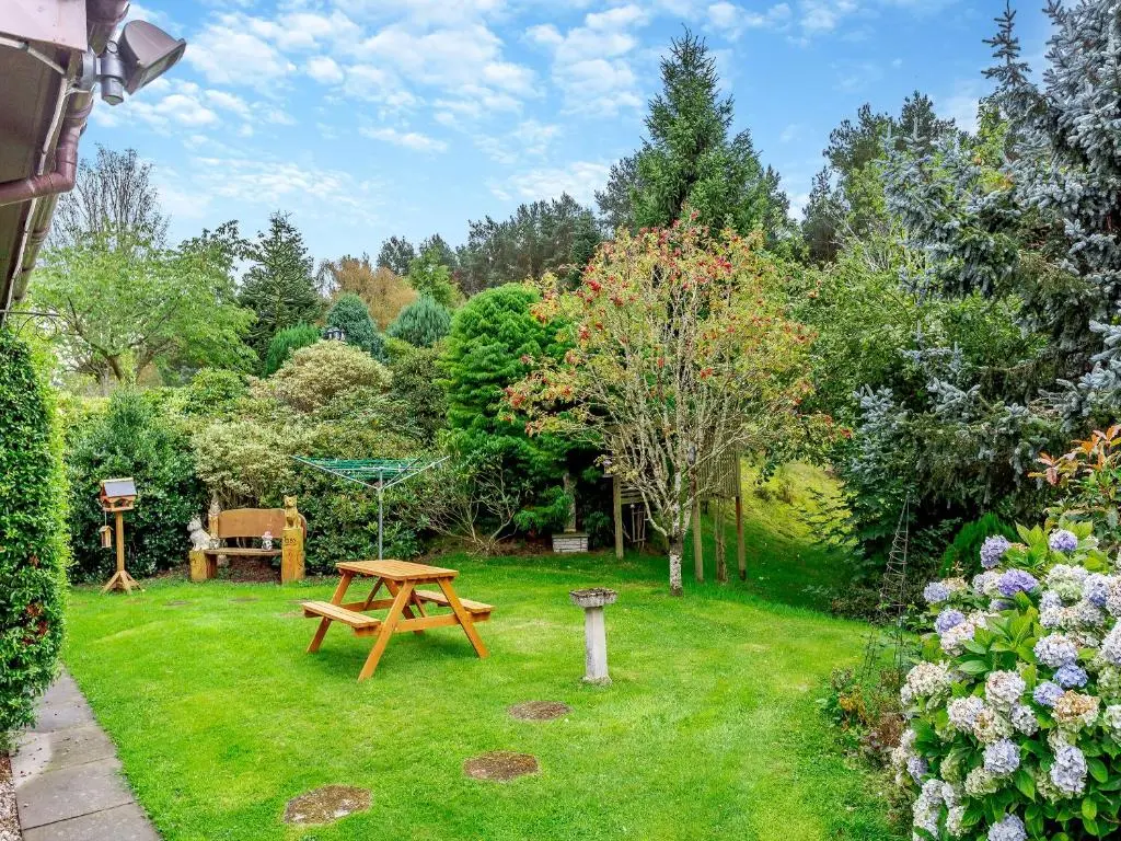 a garden with a picnic table and a swing at Drummond House Uk42979 in Brackley