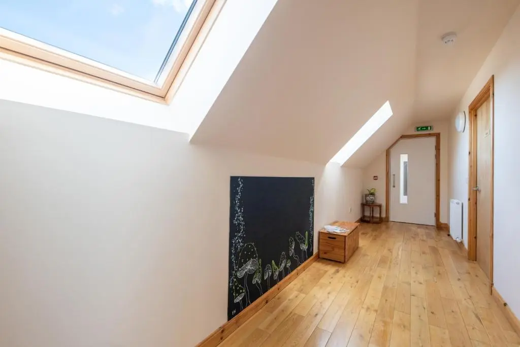 an attic hallway with a skylight in a house at Spacious 6 bedroom property on a working fruit farm in Tore