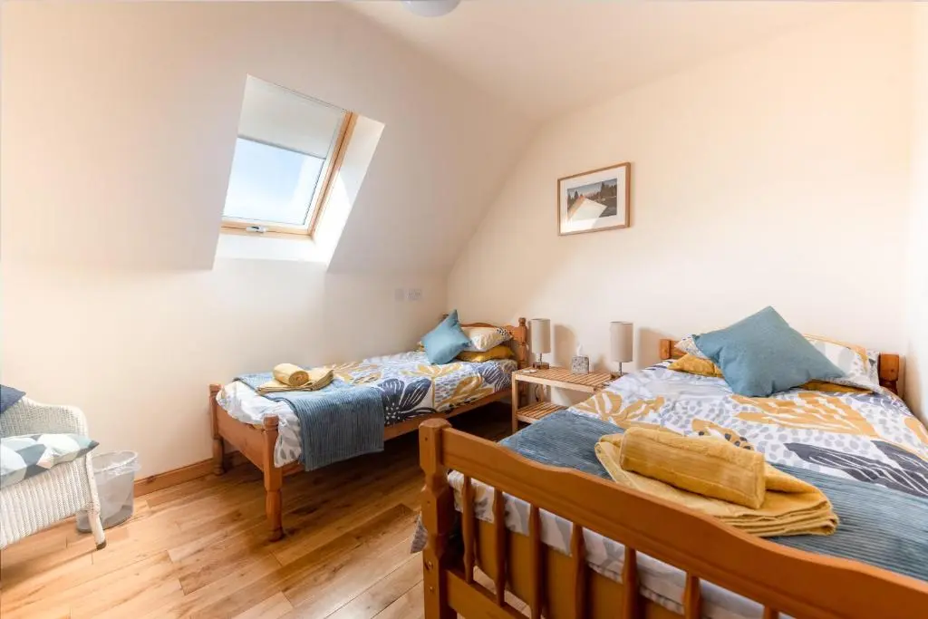a bedroom with two beds and a window at Spacious 6 bedroom property on a working fruit farm in Tore