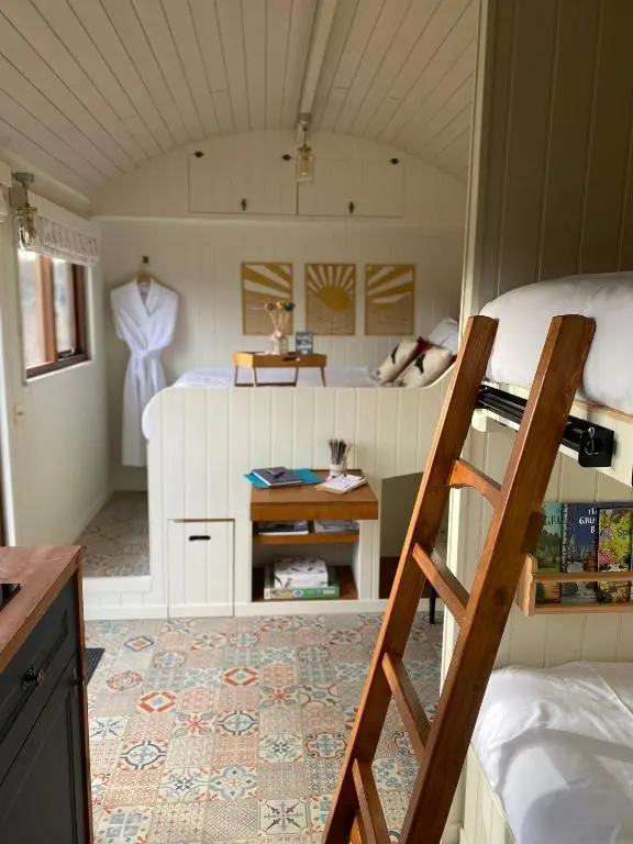 a room with a bunk bed and a ladder at Ledmacoy Shepherds Huts in Strathdon