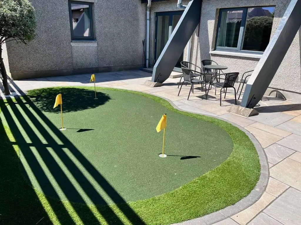 a miniature golf course in a courtyard with a table and chairs at Dune House, Golf Road, Dornoch 5x Bedrooms in Dornoch