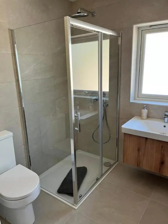 a bathroom with a shower and a toilet and a sink at Dune House, Golf Road, Dornoch 5x Bedrooms in Dornoch
