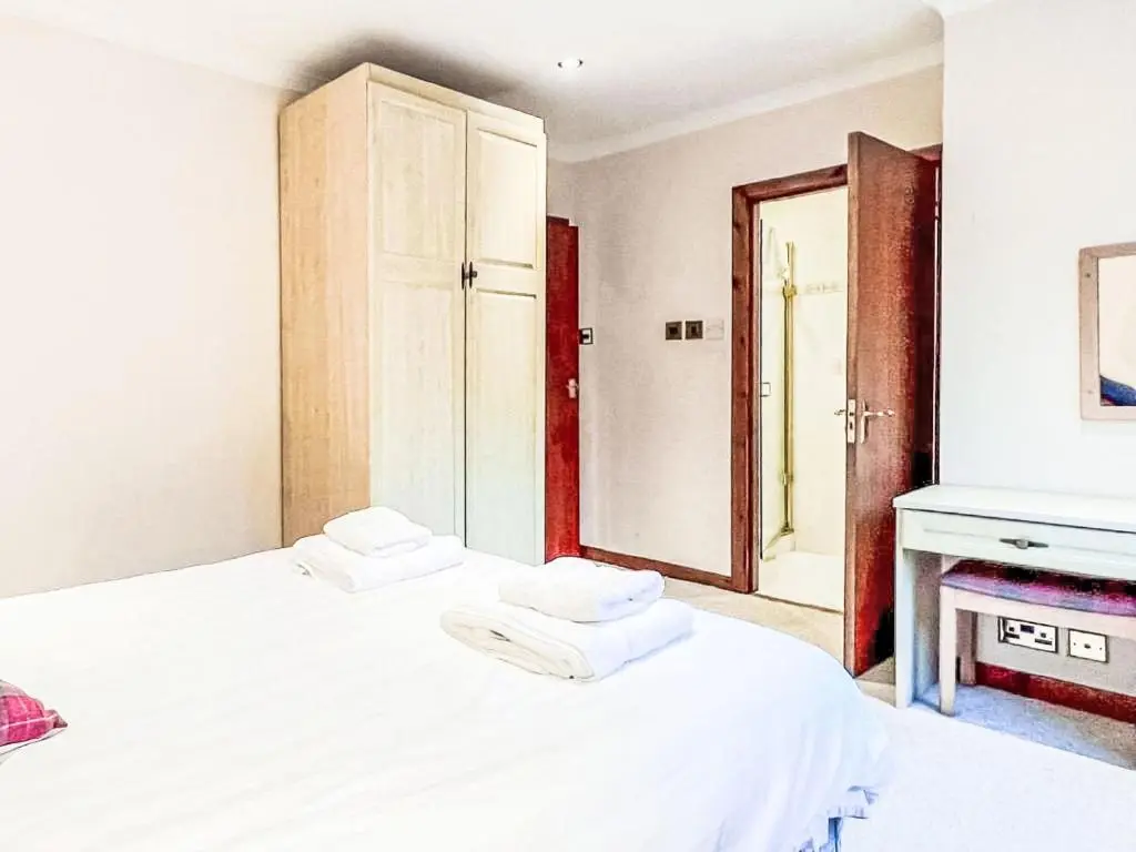 a bedroom with two beds with white sheets and a mirror at Chalet Oich View by Interhome in Spean Bridge