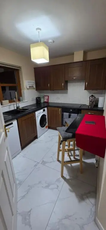 a kitchen with a table and a washing machine at Modern Dornoch Apartment in Dornoch