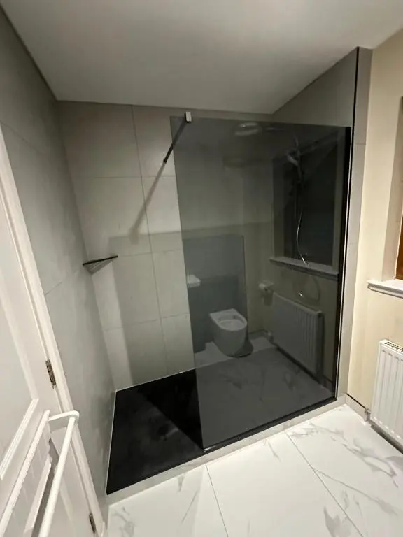 a bathroom with a toilet through a glass window at Modern Dornoch Apartment in Dornoch