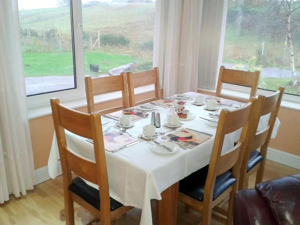 a dining room table with a white table cloth on it at Ornum House in Beauly