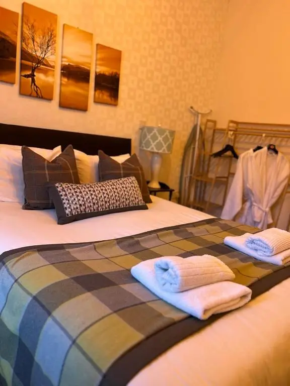 a bed with two towels sitting on top of it at Achilty Guest House in Contin
