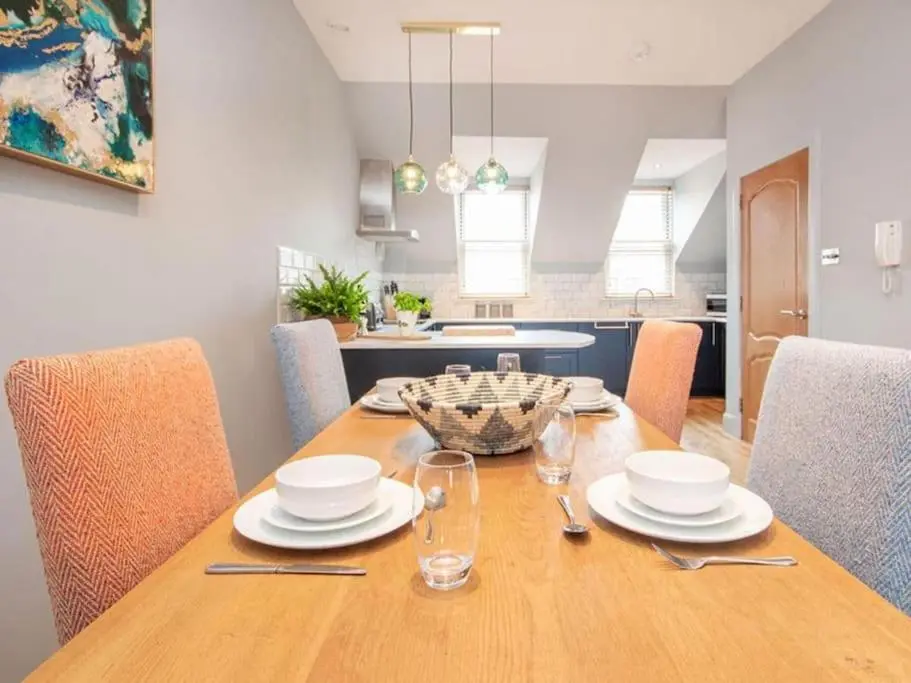 a dining room table with plates and glasses on it at Townhouse on the Square, Dornoch in Dornoch