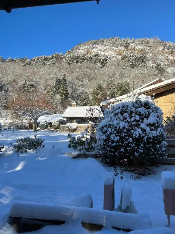 a yard covered in snow with a mountain in the background at Greenwood - Stunning Scandinavian Style Home in the heart of Ballater Royal Deeside in Ballater
