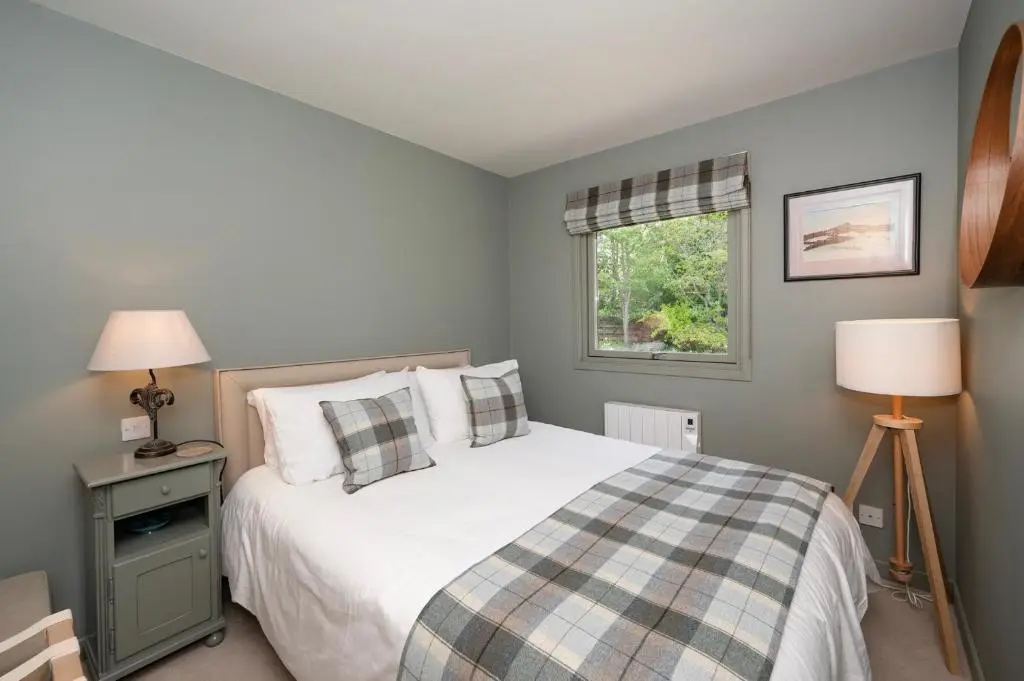 a bedroom with a bed and a window at Greenwood - Stunning Scandinavian Style Home in the heart of Ballater Royal Deeside in Ballater
