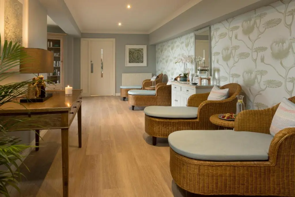 a living room with wicker chairs and a table at Golf View Hotel & Spa in Nairn