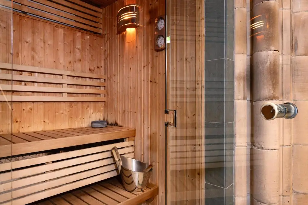 a wooden sauna with a metal bucket in it at Courtyard Cottage 3, Riverside Cottage in Fort Augustus