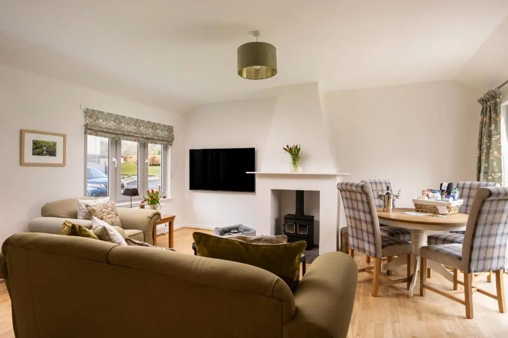 a living room with a couch and a table at Courtyard Cottage 3, Riverside Cottage in Fort Augustus
