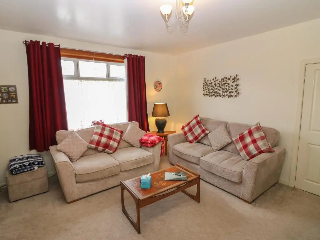 a living room with two couches and a coffee table at Thain House in Banff