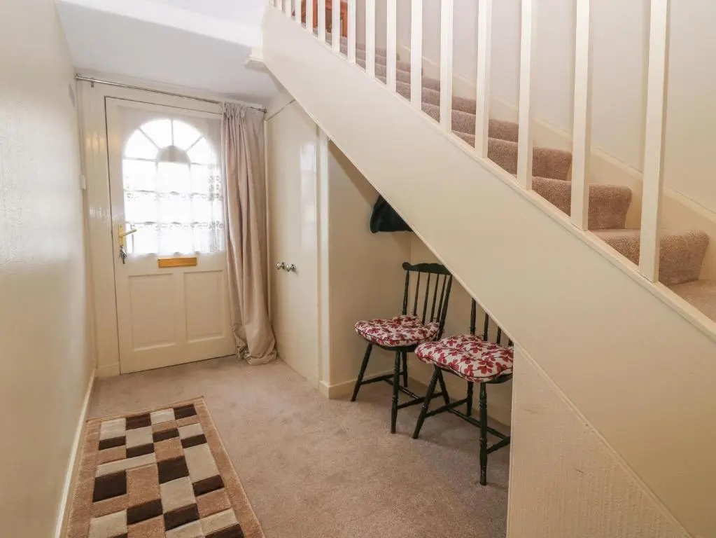 a hallway with two chairs and a stair case at Thain House in Banff