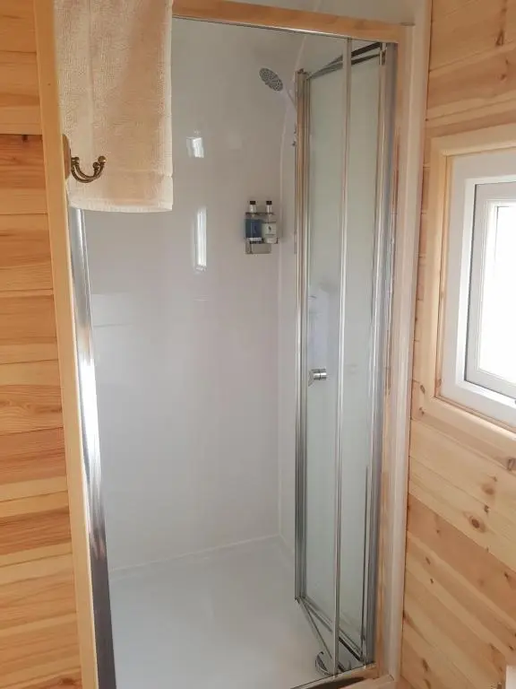 a glass shower in a bathroom with a window at Camhanaich 'Half light of dawn' in Dunbeath