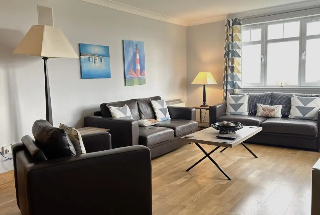 a living room with two couches and a table at No2 The Links Apartment, Brora in Brora