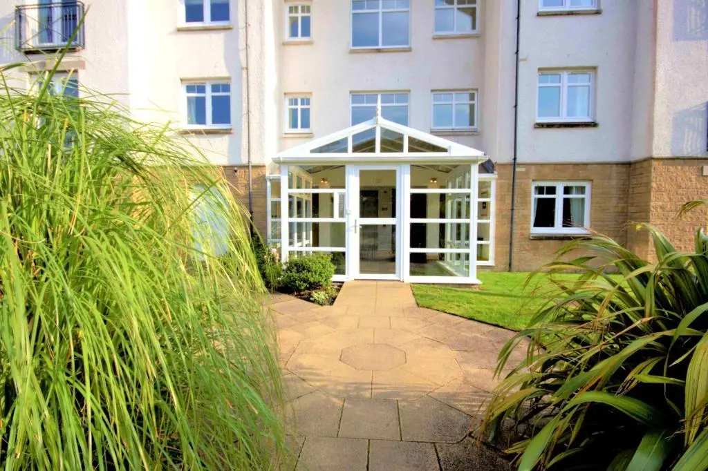 a building with a white door in front of it at No2 The Links Apartment, Brora in Brora