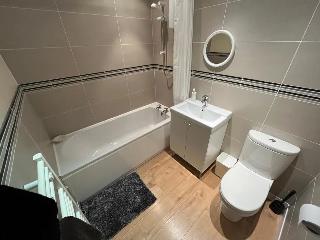 a bathroom with a toilet and a tub and a sink at Ness View Cottage in Fort Augustus