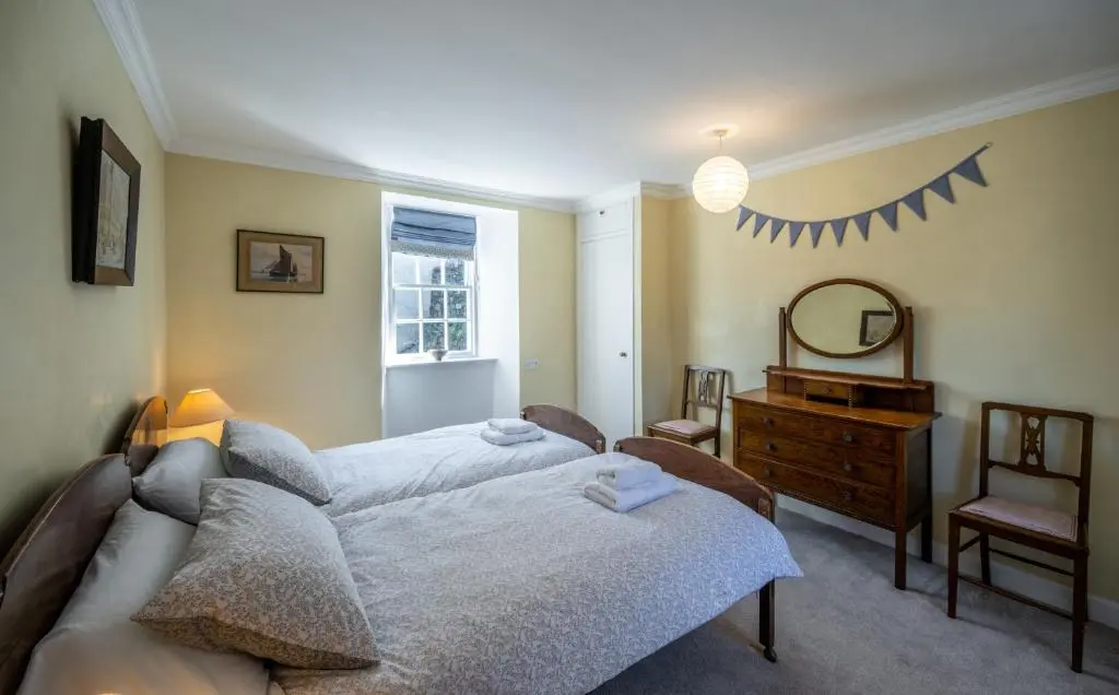 a bedroom with a bed and a dresser and a mirror at 7 Shorehead, Portsoy in Portsoy
