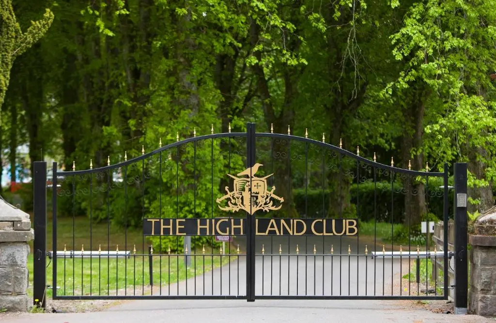 a black iron gate with the high land club sign at Highland Club Direct in Fort Augustus