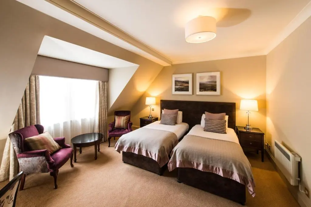 a hotel room with two beds and a window at Thainstone House in Inverurie