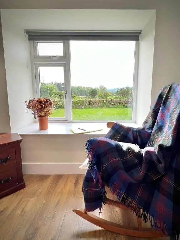 a living room with a chair and a window at Cosy Country House in Deeside in Finzean