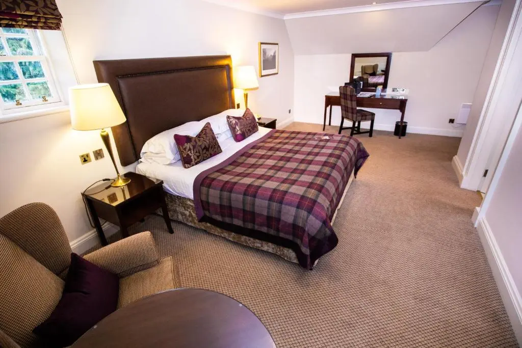 a hotel room with a bed and a desk at Macdonald Pittodrie House in Chapel of Garioch