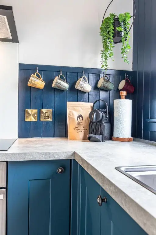 a kitchen with blue cabinets and a counter top at Lachie's Townhouse in Inverness