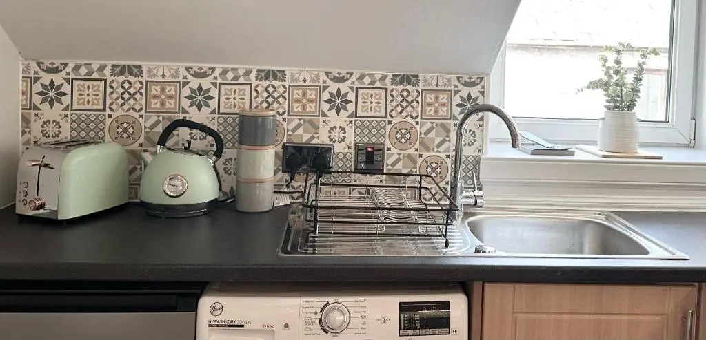 a kitchen counter with a sink and a dishwasher at Haugh Hideaway in Inverness