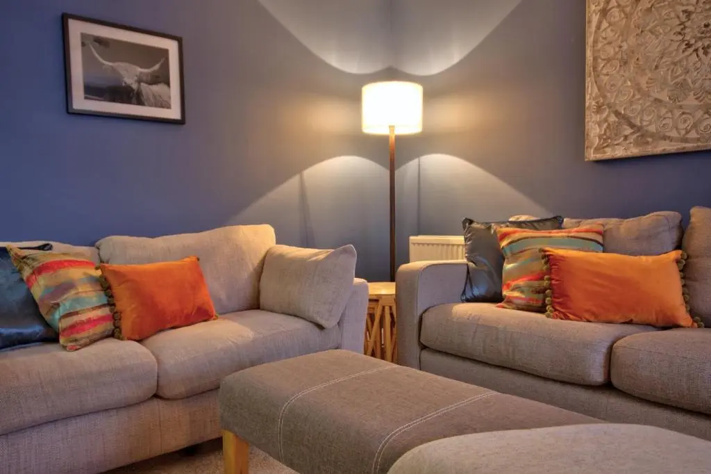 a living room with two couches and a lamp at Otago Cottage, Brora in Brora