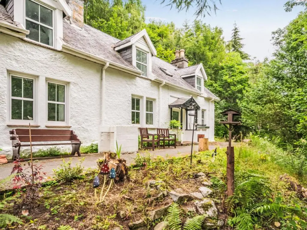 an exterior view of a white house with a garden at Holiday Home Dancot by Interhome in Invermoriston