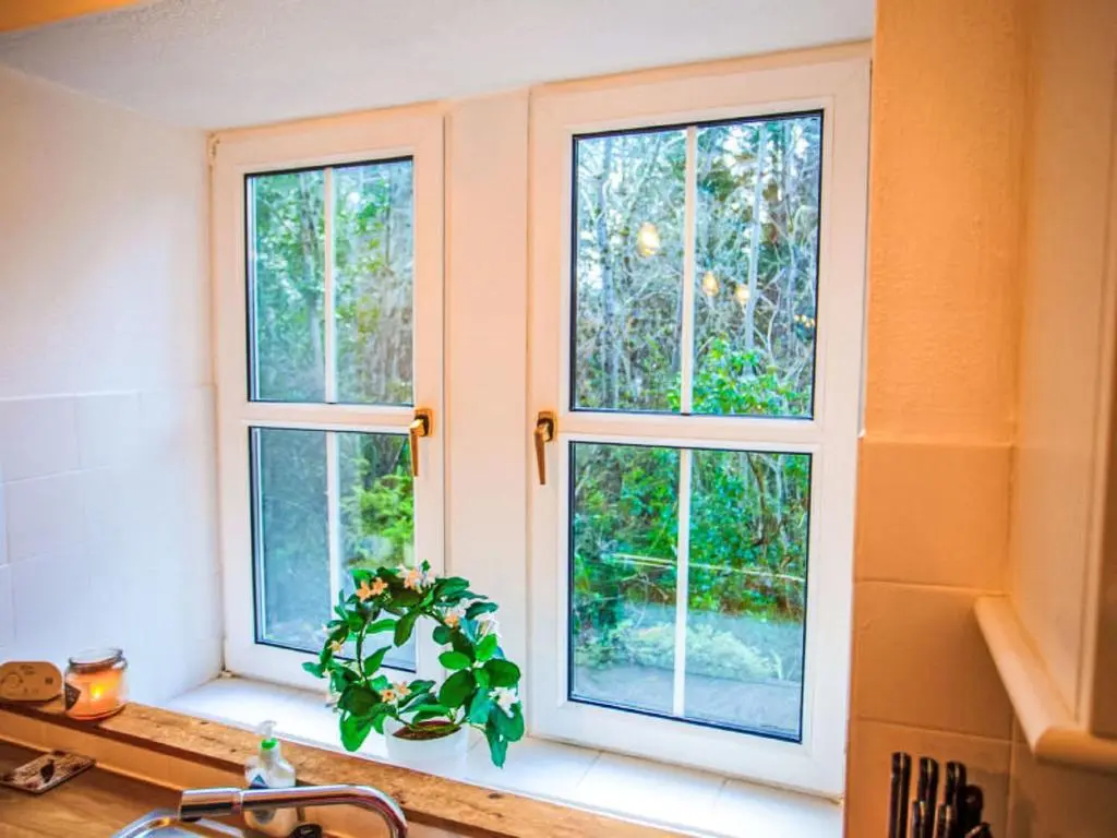 three windows in a kitchen with a plant on a counter at Holiday Home Dancot by Interhome in Invermoriston