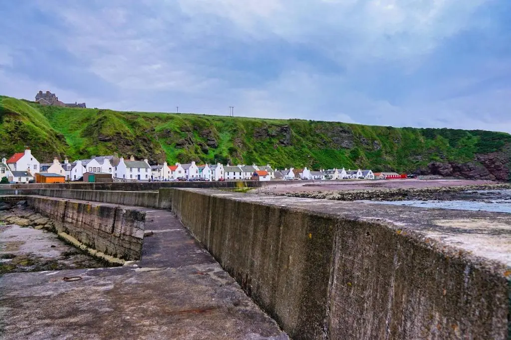 a row of houses on the shore of a beach at The Pennan Inn in Pennan