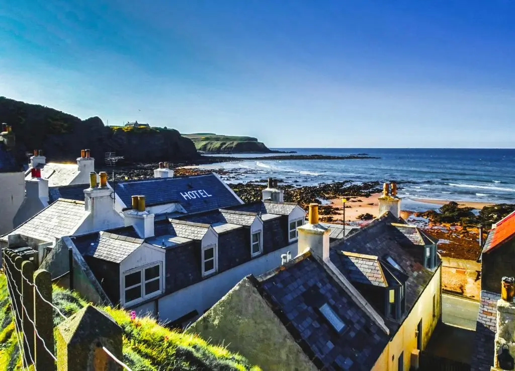an aerial view of a house and the ocean at The Pennan Inn in Pennan