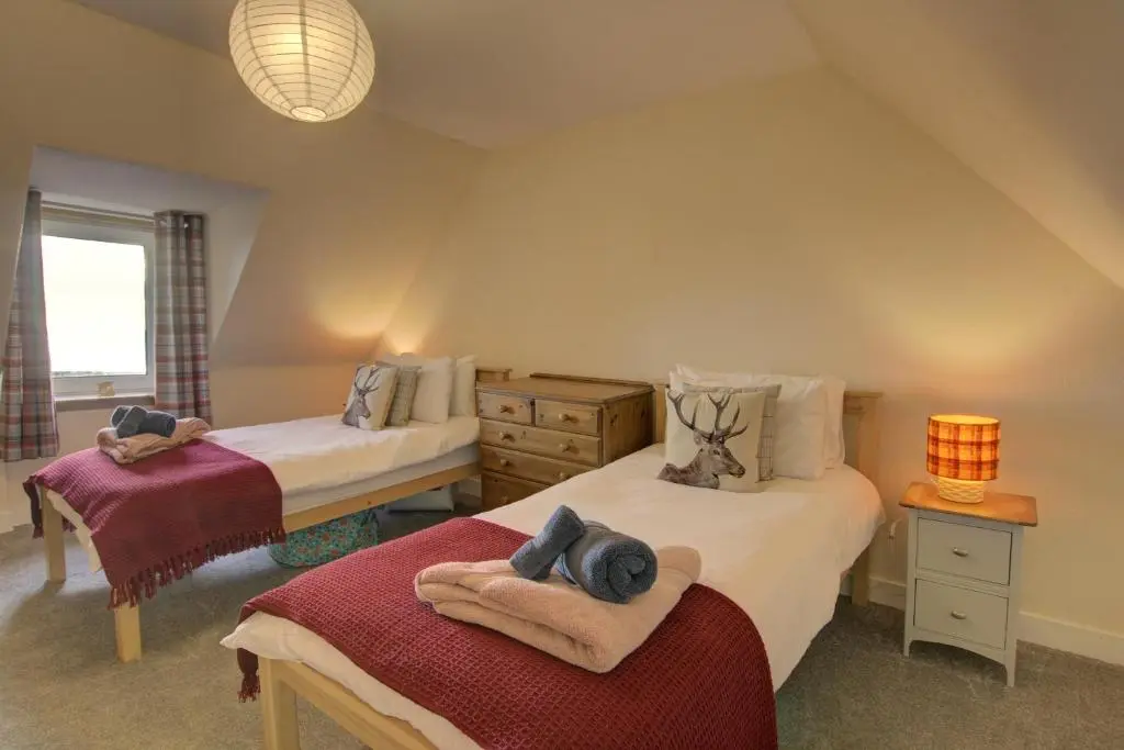 a bedroom with two beds with towels on them at Tigh-na-Mara, Helmsdale in Helmsdale