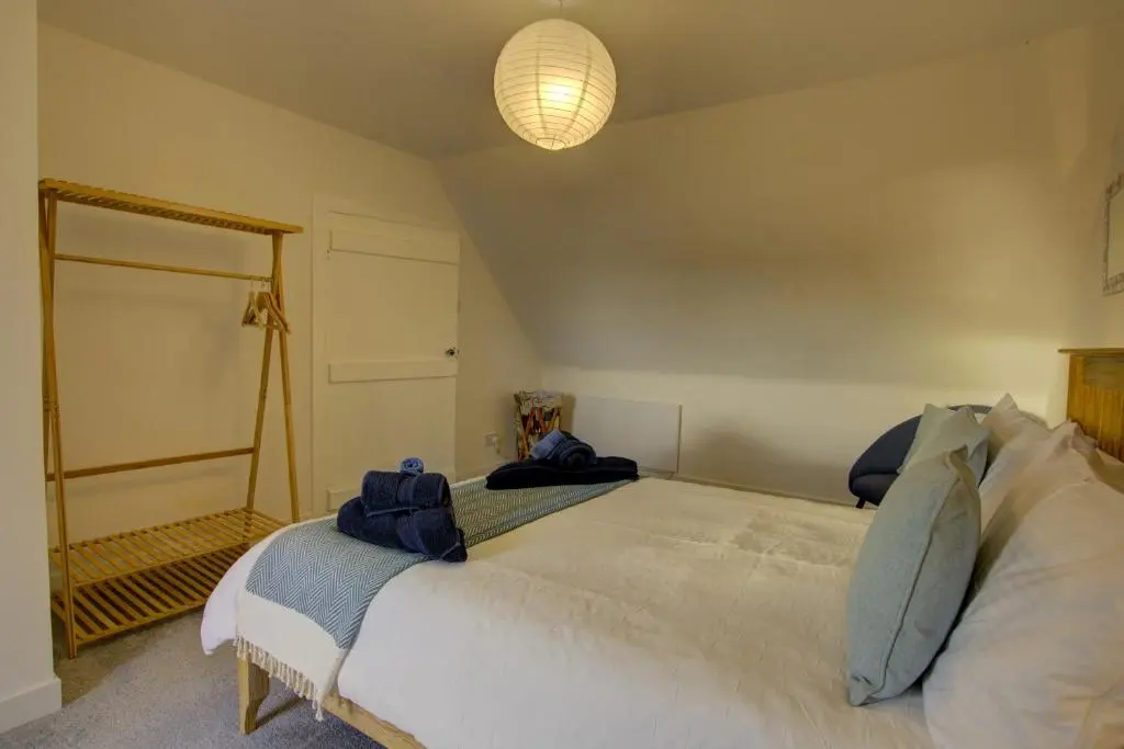 a bedroom with a large bed and a mirror at Tigh-na-Mara, Helmsdale in Helmsdale